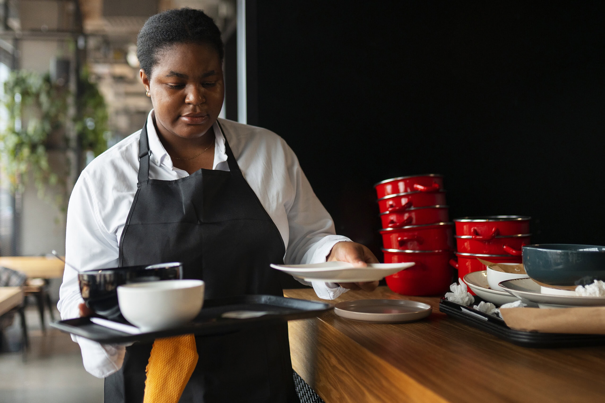 Punëtor i larmishëm ugandas që përgatit ushqim në një restorant, duke theksuar punësimin dhe vendet e punës në mikpritje në Ugandë.