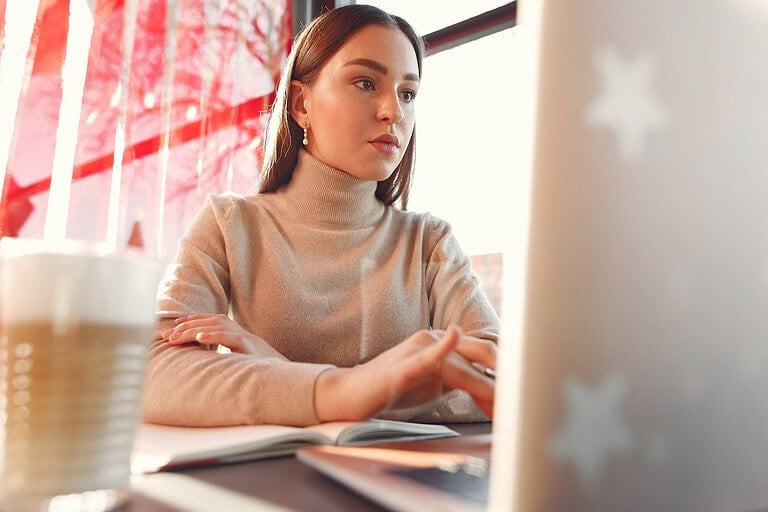 Anëtar i ekipit të Fenix Consulting & Recruiting duke punuar në kompjuter në një mjedis zyre.